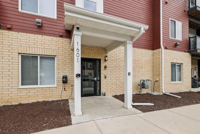 1601 N Windsor Ave Unit 106, Cottage Grove, WI 53527 - view of exterior entry featuring brick siding and a surveillance system
