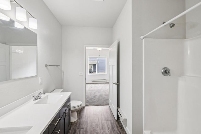 1601 N Windsor Ave Unit 106, Cottage Grove, WI 53527 - bathroom featuring baseboard heating, a shower, double vanity, wood finished floors, and a baseboard radiator