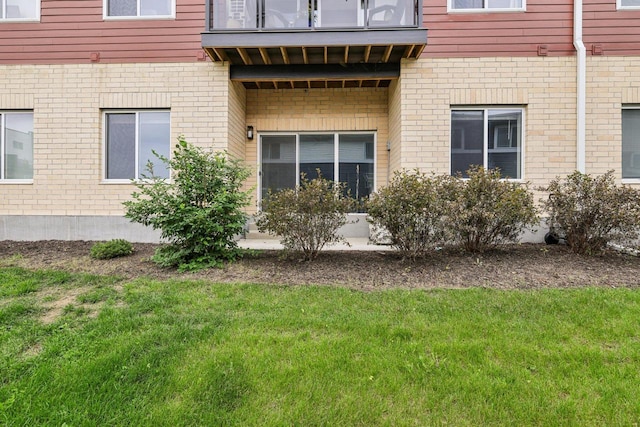 1601 N Windsor Ave Unit 106, Cottage Grove, WI 53527 - view of home's exterior featuring brick siding, a balcony, and a yard