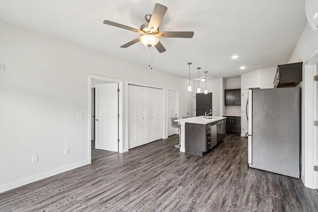 1601 N Windsor Ave Unit 106, Cottage Grove, WI 53527 - kitchen featuring stainless steel appliances, light countertops, a ceiling fan, an island with sink, and dark wood finished floors