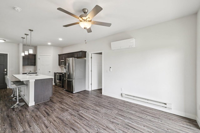 1601 N Windsor Ave Unit 106, Cottage Grove, WI 53527 - kitchen with stainless steel appliances, a baseboard radiator, an AC wall unit, dark wood-style floors, and light countertops