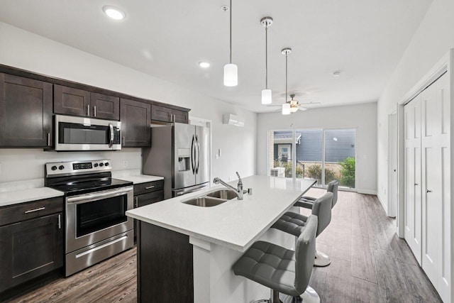 1601 N Windsor Ave Unit 106, Cottage Grove, WI 53527 - kitchen featuring appliances with stainless steel finishes, a breakfast bar area, light countertops, a kitchen island with sink, and recessed lighting