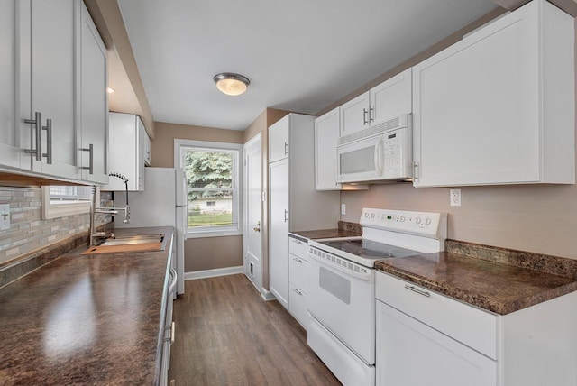 1961 S 94th St, West Allis, WI 53227 - kitchen featuring white appliances, dark countertops, backsplash, dark wood-style flooring, and white cabinetry