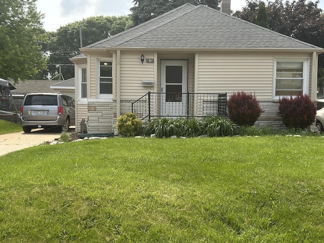 1961 S 94th St, West Allis, WI 53227 - view of front facade featuring roof with shingles, a front yard, and stone siding