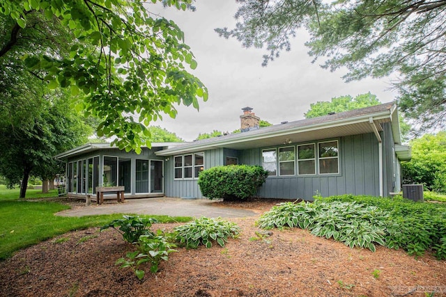 1813 Countryside Dr, Middleton, WI 53562 - back of house featuring a sunroom, a chimney, board and batten siding, and a patio area