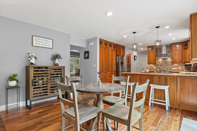 N80W32229 Northbrook Ct, Hartland, WI 53029 - dining space featuring light wood-style floors, recessed lighting, and arched walkways