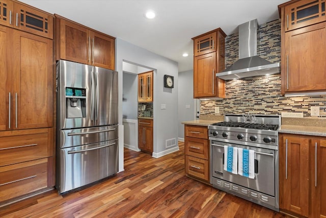 N80W32229 Northbrook Ct, Hartland, WI 53029 - kitchen with wall chimney exhaust hood, appliances with stainless steel finishes, tasteful backsplash, dark wood-style flooring, and recessed lighting