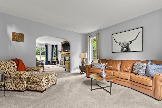 N80W32229 Northbrook Ct, Hartland, WI 53029 - living room with arched walkways, carpet floors, healthy amount of natural light, and a fireplace