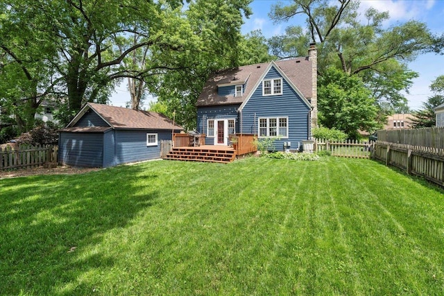 4705 Gordon Ave, Monona, WI 53716 - back of house featuring a deck, a fenced backyard, an outbuilding, a chimney, and a detached garage