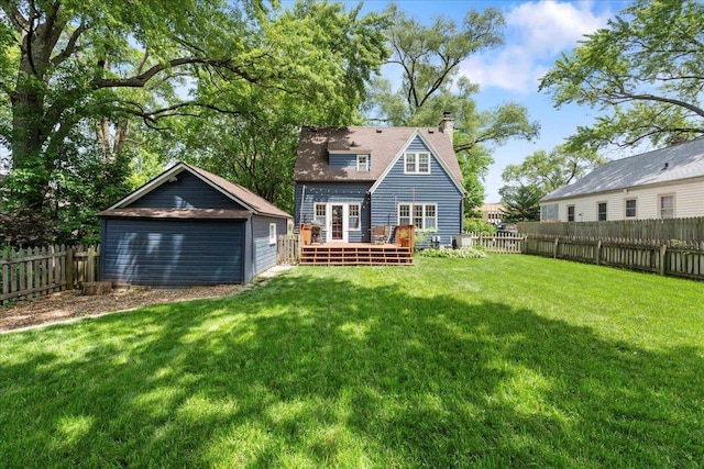 4705 Gordon Ave, Monona, WI 53716 - back of property featuring a wooden deck, a fenced backyard, an outbuilding, a garage, and a chimney
