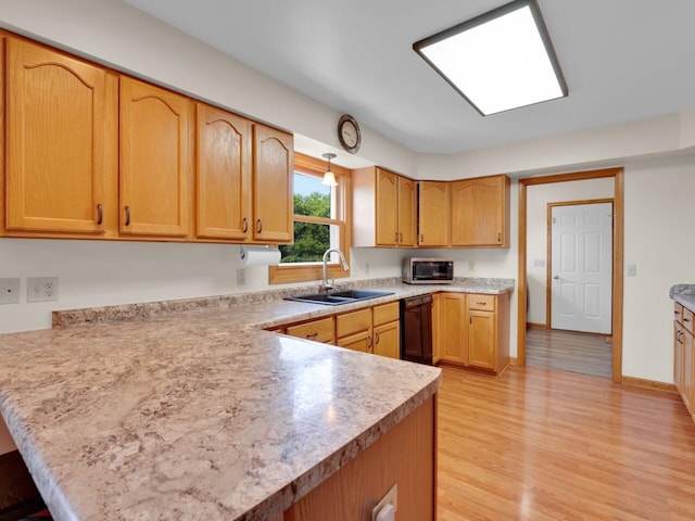 26317 Dukleth Dr, Waterford, WI 53185 - kitchen featuring stainless steel microwave, a peninsula, black dishwasher, light wood-style floors, and light countertops