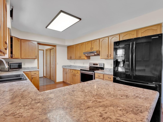 26317 Dukleth Dr, Waterford, WI 53185 - kitchen with stainless steel electric range oven, under cabinet range hood, black refrigerator with ice dispenser, light countertops, and light wood-style flooring