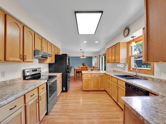 26317 Dukleth Dr, Waterford, WI 53185 - kitchen featuring black appliances, under cabinet range hood, a peninsula, light wood-style flooring, and decorative light fixtures