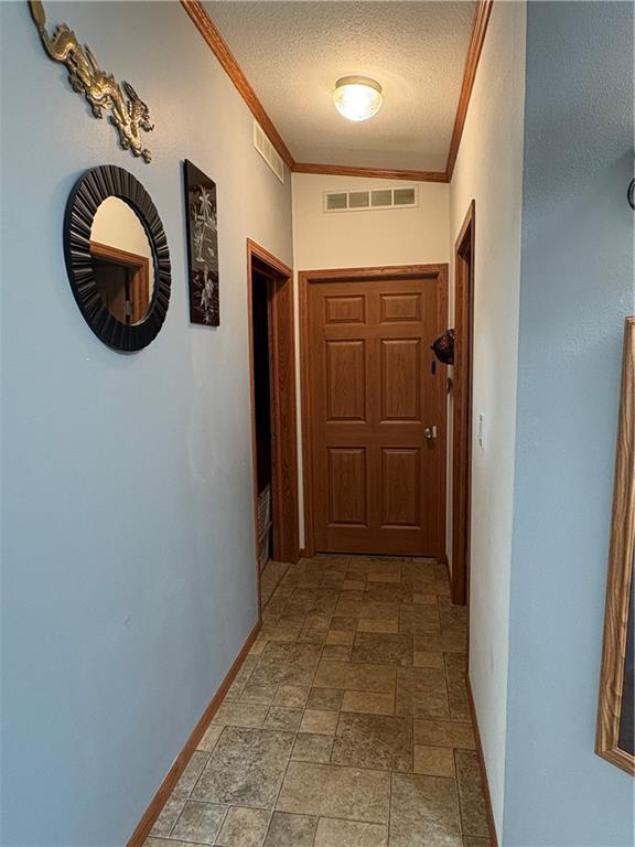 733 W Old Highway 54, Pittsville, WI 54466 - corridor with crown molding, a textured ceiling, and light stone finish floors