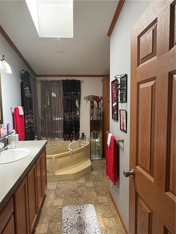 733 W Old Highway 54, Pittsville, WI 54466 - full bathroom featuring crown molding, a skylight, a garden tub, vanity, and stone finish floors