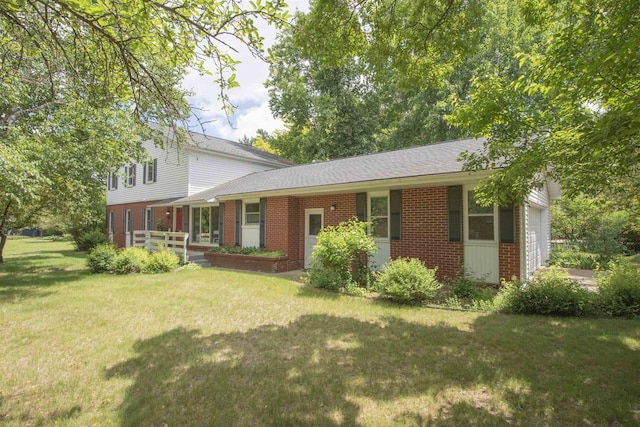 4201 Janick Cir, Stevens Point, WI 54481 - view of front of home featuring brick siding, a front yard, a garage, and a shingled roof