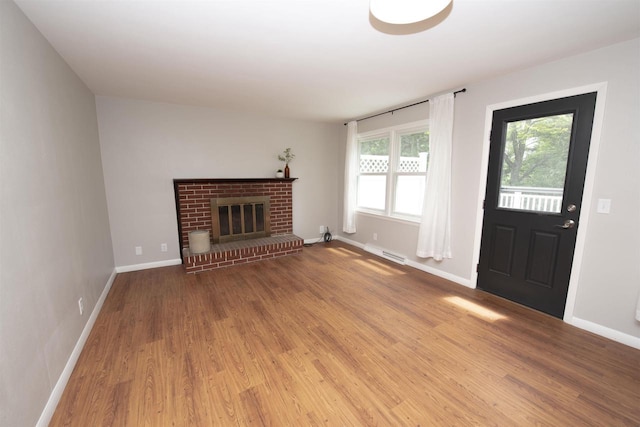 4201 Janick Cir, Stevens Point, WI 54481 - unfurnished living room with wood finished floors and a brick fireplace