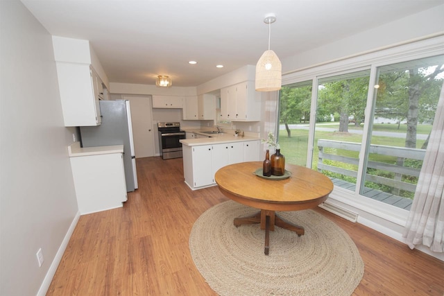 4201 Janick Cir, Stevens Point, WI 54481 - kitchen featuring stainless steel appliances, light countertops, white cabinetry, light wood-type flooring, and recessed lighting