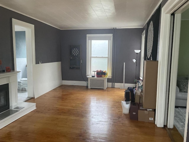 840 Lincoln Blvd, Manitowoc, WI 54220 - living area with radiator heating unit, crown molding, wood finished floors, and a glass covered fireplace