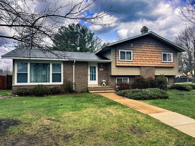 2709 Richard St, Marinette, WI 54143 - split level home featuring brick siding, a front lawn, and a chimney