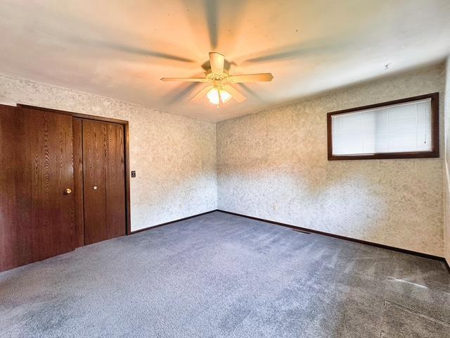 2709 Richard St, Marinette, WI 54143 - unfurnished bedroom featuring dark colored carpet, a closet, and ceiling fan