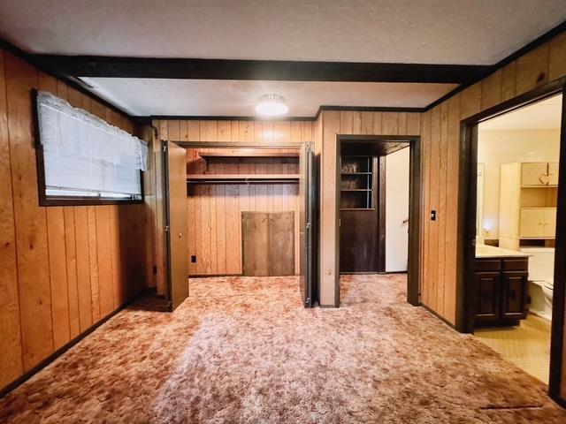 2709 Richard St, Marinette, WI 54143 - unfurnished bedroom featuring wooden walls, light colored carpet, and beamed ceiling