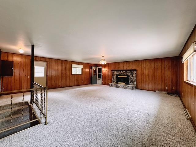 2709 Richard St, Marinette, WI 54143 - unfurnished living room featuring plenty of natural light, wood walls, carpet flooring, and a fireplace