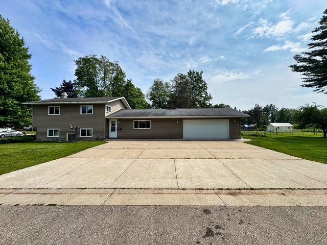 2709 Richard St, Marinette, WI 54143 - split level home featuring a front yard, an attached garage, and concrete driveway