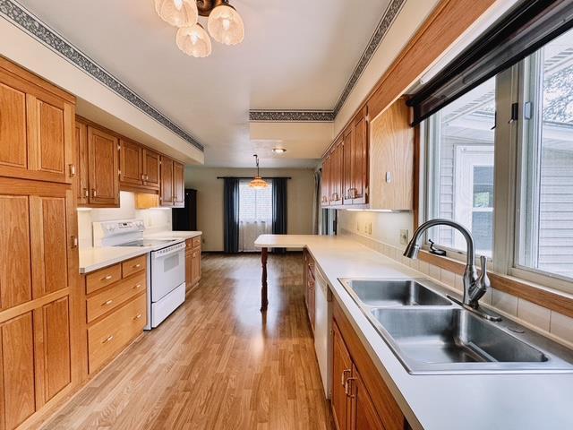 2709 Richard St, Marinette, WI 54143 - kitchen featuring white electric stove, brown cabinetry, light wood finished floors, and pendant lighting