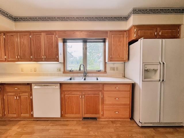 2709 Richard St, Marinette, WI 54143 - kitchen featuring white appliances, light countertops, brown cabinetry, and light wood-style flooring