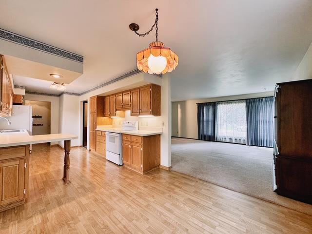 2709 Richard St, Marinette, WI 54143 - kitchen featuring white appliances, light countertops, light wood-style flooring, open floor plan, and brown cabinetry