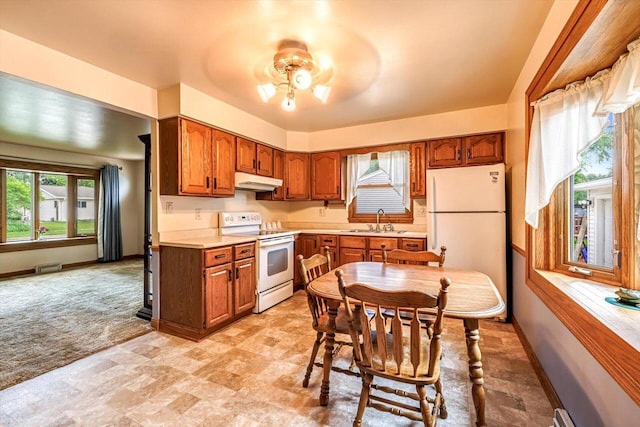 1981 Jan Ave, Waukesha, WI 53188 - kitchen featuring white appliances, under cabinet range hood, light countertops, brown cabinets, and light colored carpet