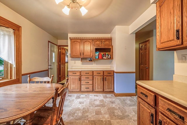 1981 Jan Ave, Waukesha, WI 53188 - kitchen featuring brown cabinets, stone finish flooring, light countertops, and open shelves