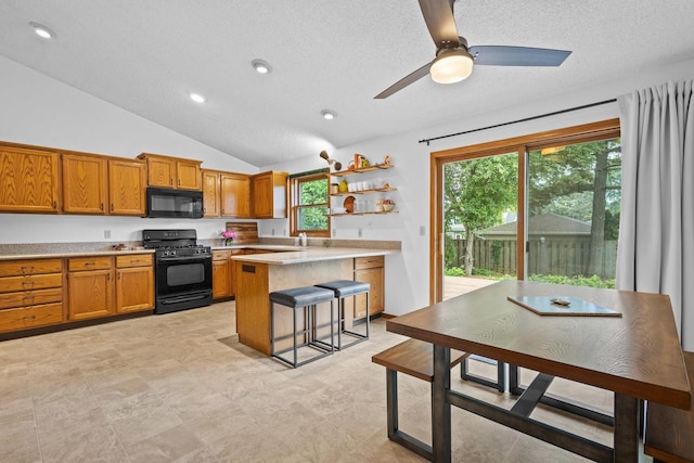 1001 W Taylor St, Appleton, WI 54914 - kitchen featuring black appliances, a kitchen bar, light countertops, brown cabinetry, and vaulted ceiling