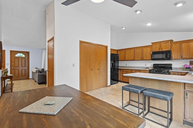 1001 W Taylor St, Appleton, WI 54914 - kitchen featuring black appliances, high vaulted ceiling, brown cabinets, a breakfast bar, and light countertops