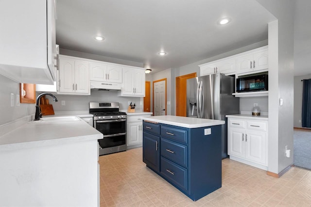 2847 Virgo Rd, Green Bay, WI 54311 - kitchen with stainless steel appliances, blue cabinetry, under cabinet range hood, white cabinets, and a kitchen island