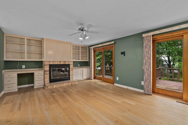 9315 N Shore Dr, Harshaw, WI 54529 - unfurnished living room with healthy amount of natural light, a ceiling fan, light wood finished floors, and a glass covered fireplace