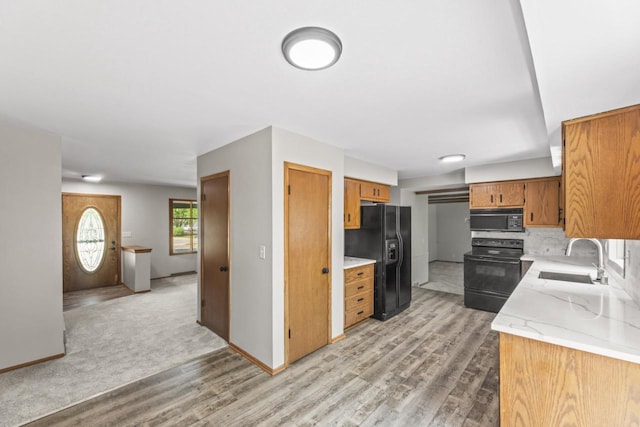 6101 W Edgerton Ave, Greendale, WI 53129 - kitchen with black appliances, light wood-style floors, brown cabinets, and decorative backsplash