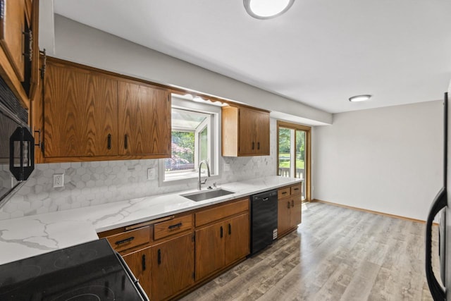 6101 W Edgerton Ave, Greendale, WI 53129 - kitchen with black appliances, tasteful backsplash, light wood-style floors, brown cabinetry, and light stone counters