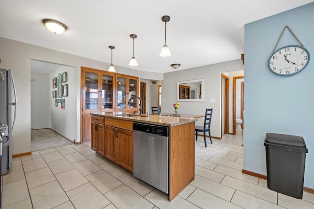 7939 32nd Ave, Kenosha, WI 53144 - kitchen with stainless steel dishwasher, brown cabinetry, an island with sink, light stone counters, and pendant lighting
