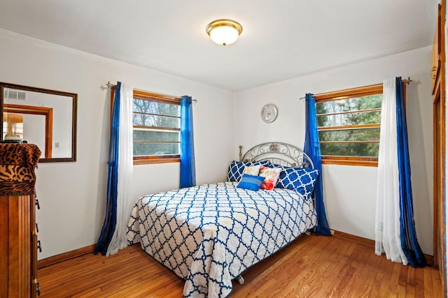 1100 W Fairy Chasm Rd, River Hills, WI 53217 - bedroom with wood finished floors and multiple windows