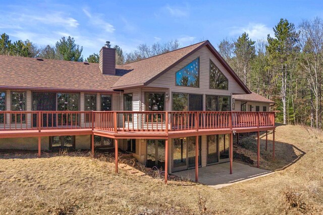 W11686 Buttercup Ave, Hancock, WI 54943 - back of property with a chimney, a wooden deck, a shingled roof, and a patio