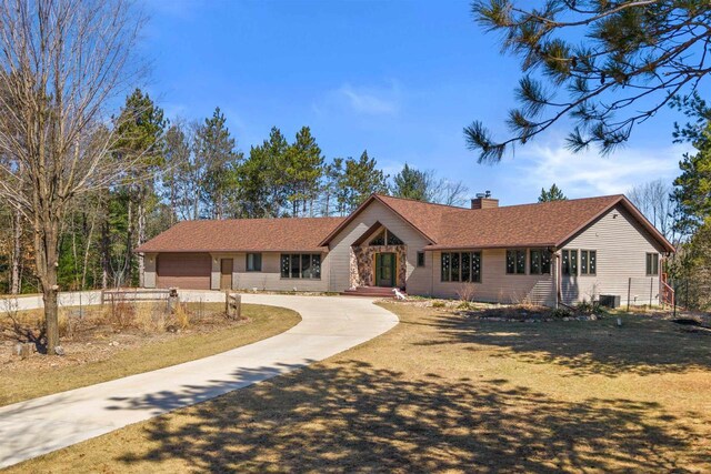 W11686 Buttercup Ave, Hancock, WI 54943 - ranch-style home featuring curved driveway, a chimney, an attached garage, and a shingled roof