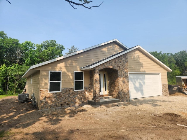 8106 Monroe St Unit 8112, Burlington, WI 53105 - view of front of house featuring dirt driveway, an attached garage, and stone siding