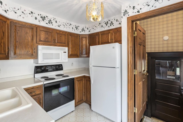 209 N Rankin St, Appleton, WI 54911 - kitchen featuring white appliances, light countertops, light flooring, and a chandelier
