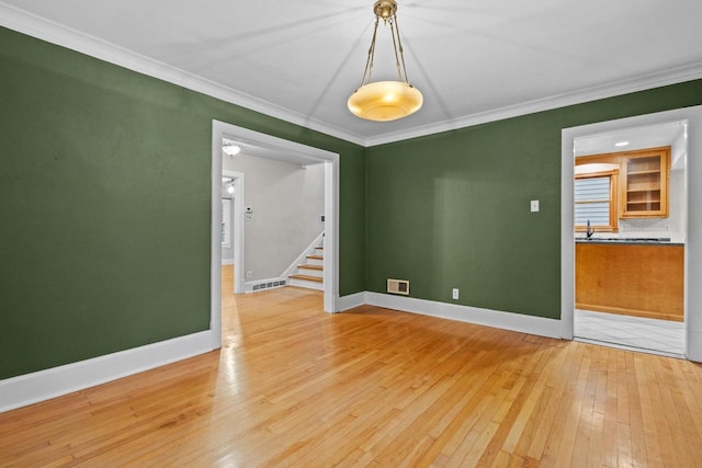 928 Emilie St, Green Bay, WI 54301 - empty room with hardwood / wood-style flooring, stairway, and crown molding