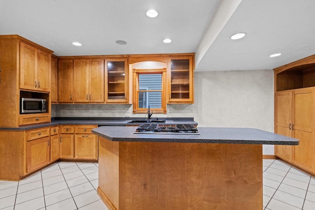 928 Emilie St, Green Bay, WI 54301 - kitchen with light tile patterned flooring, stainless steel appliances, a kitchen island, recessed lighting, and glass insert cabinets