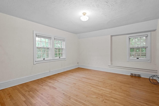 928 Emilie St, Green Bay, WI 54301 - spare room featuring wood-type flooring and a textured ceiling