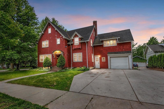 928 Emilie St, Green Bay, WI 54301 - traditional home with a chimney, a lawn, concrete driveway, an attached garage, and roof with shingles