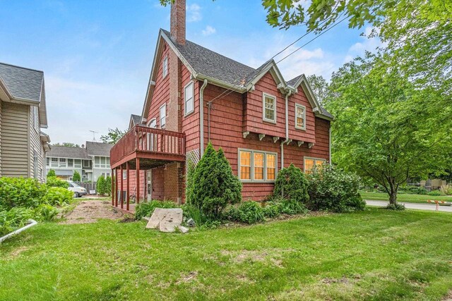 928 Emilie St, Green Bay, WI 54301 - view of property exterior featuring a chimney, a lawn, roof with shingles, and a deck